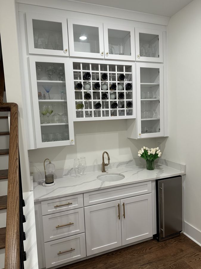 Wet bar with glass-front uppers and a wine lattice
